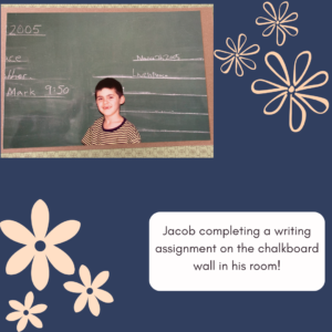 Jacob completing a writing assignment on his chalkboard wall in his room.